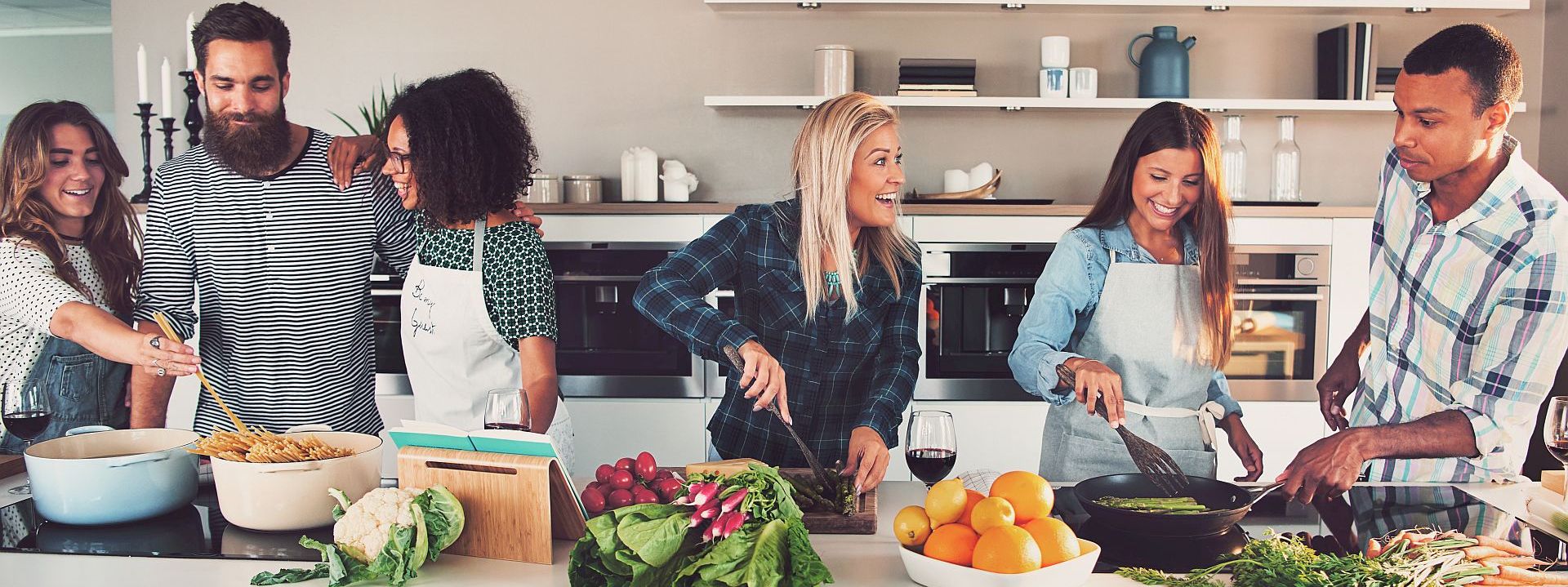 Six mixed Black and Caucasian friends cooking food